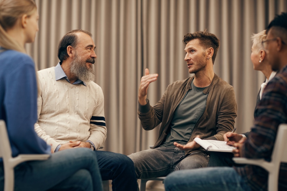 group of people having a discussion while sitting in a circle