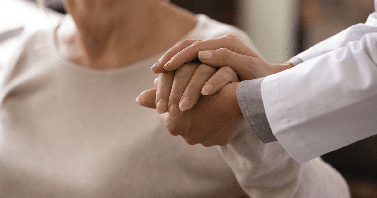 A doctor holding patient's hand.