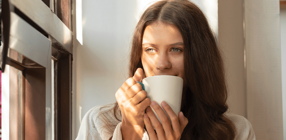 woman suffering from seasonal affective disorder in Alaska sipping from a mug