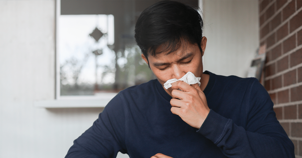 Man blowing his nose.