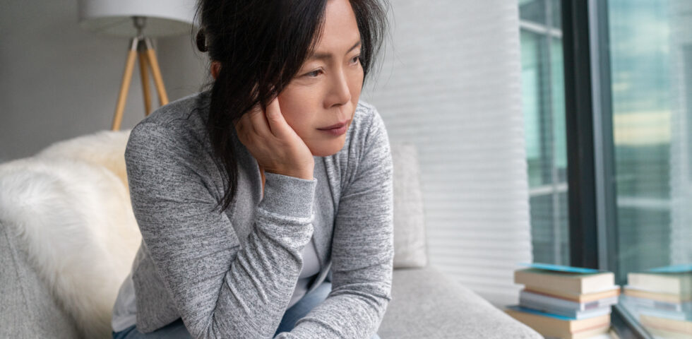 woman sitting on a coach looking out a window