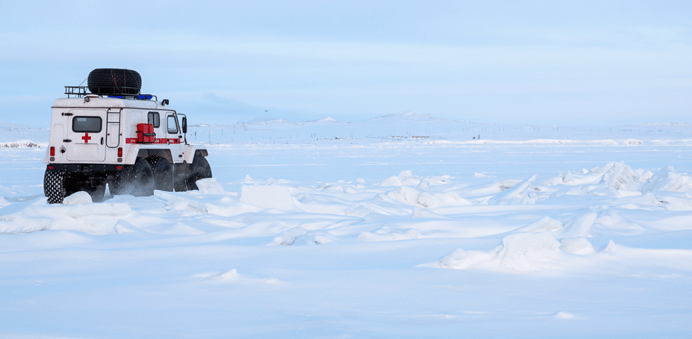 Emergency vehicle driving through snow.