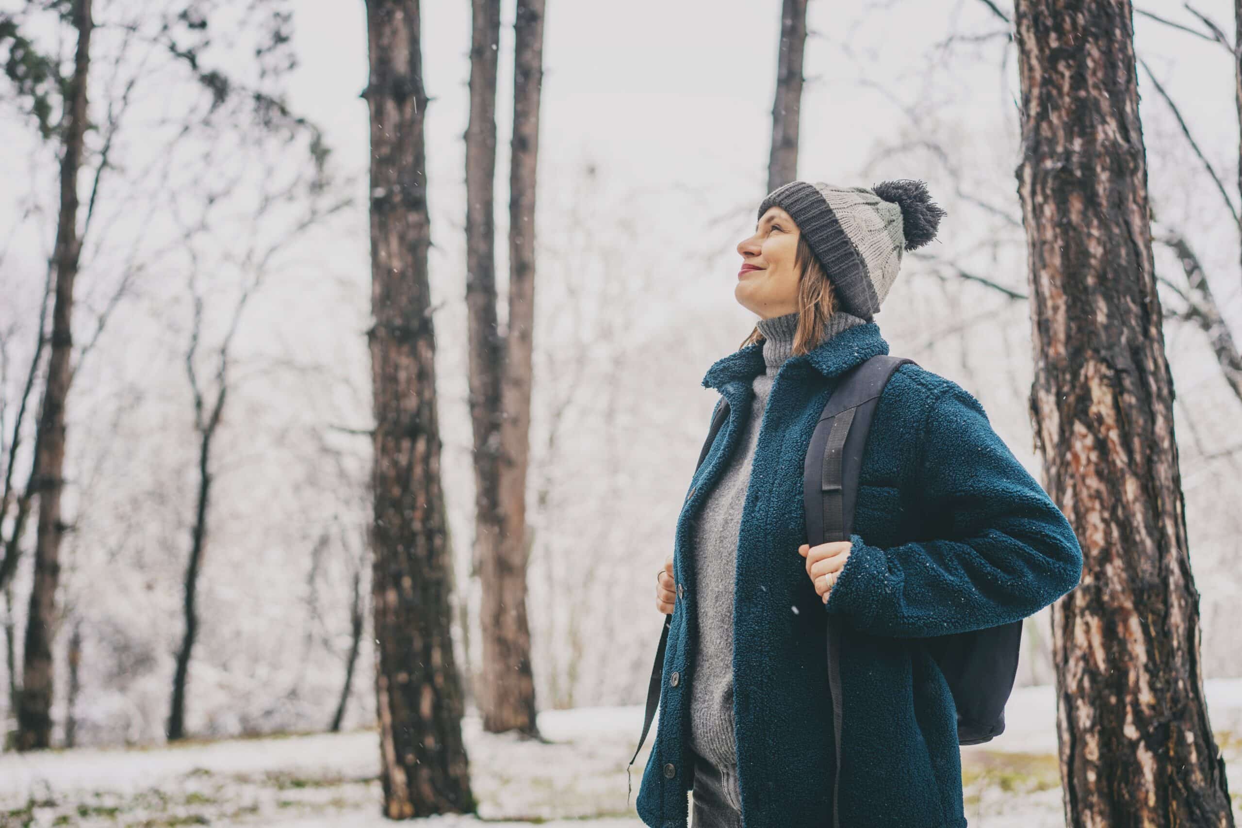 Woman walking in the woods in winter.